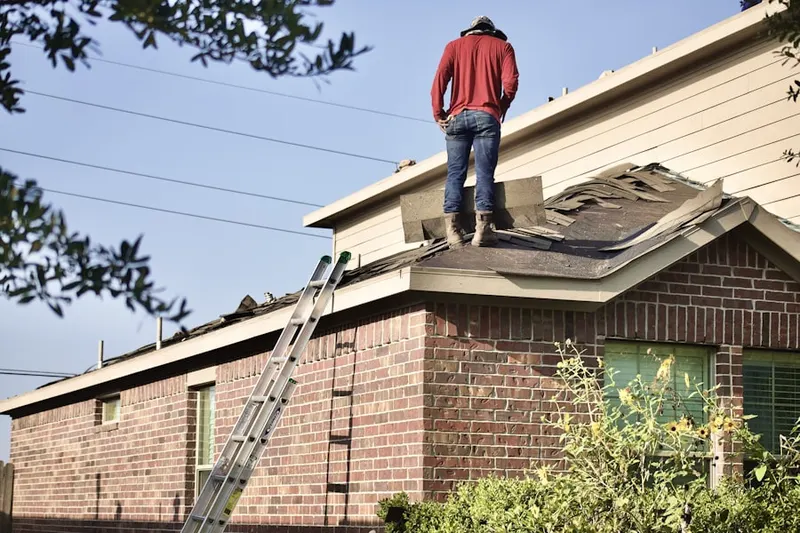 Professional roofer working on a residential roof in Towaco